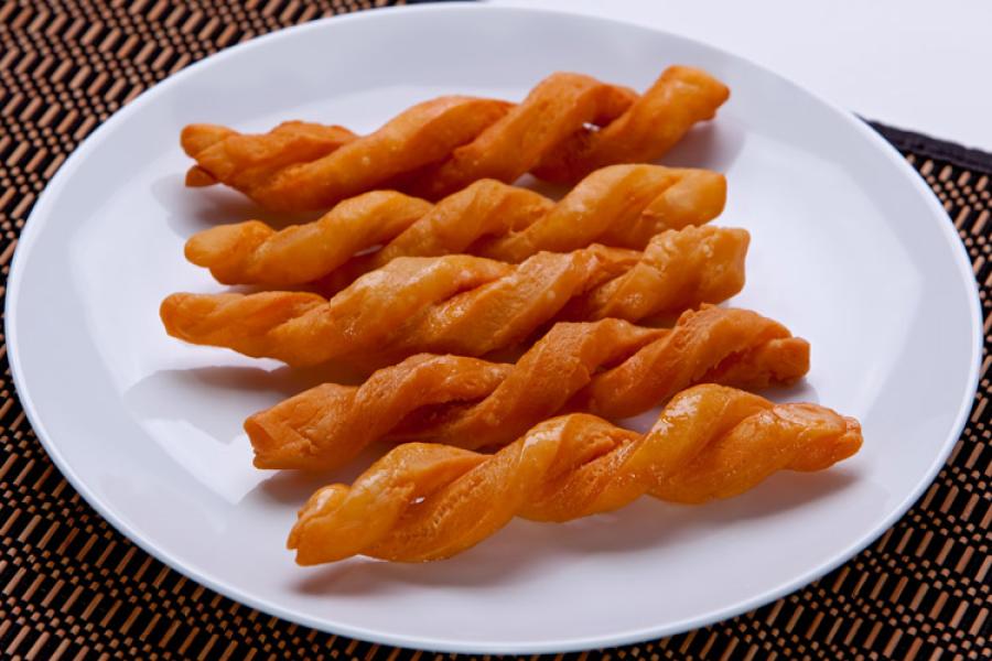 Koeksisters de doble trenza sobre un plato.