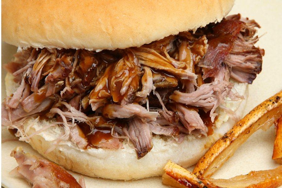 Bocadillo de carne de cerdo asada con salsa barbacoa.
