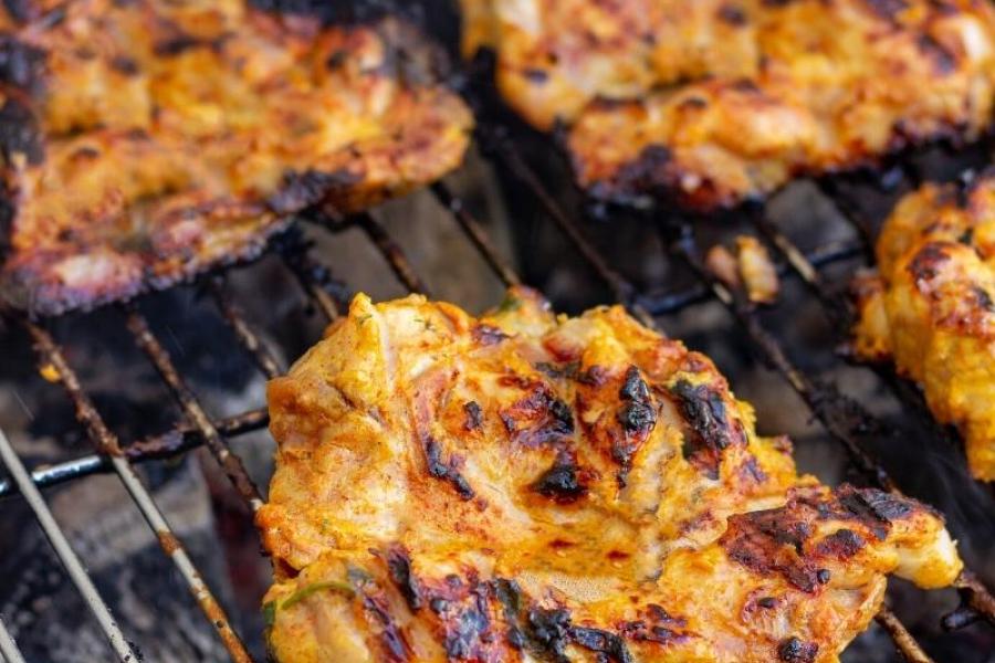 Pollo al yogur cocinándose sobre las brasas.