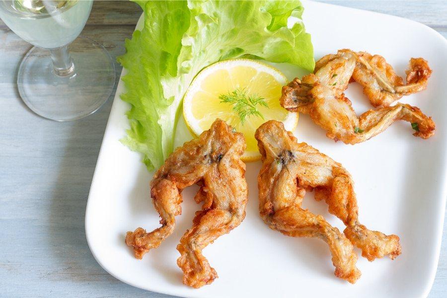Ancas de rana fritas en una fuente acompañadas de lechuga.