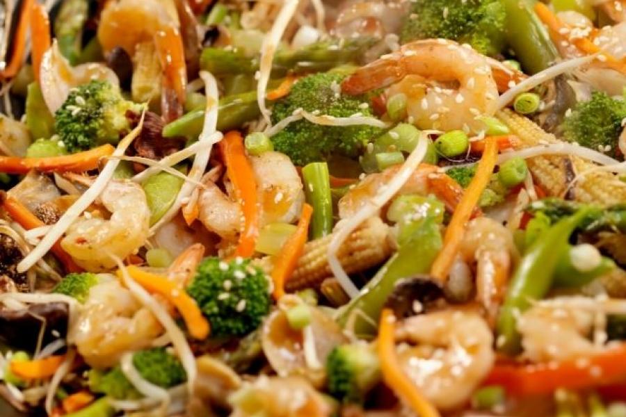 Gambas y verduras salteadas al estilo chino recién hechas y humeantes.