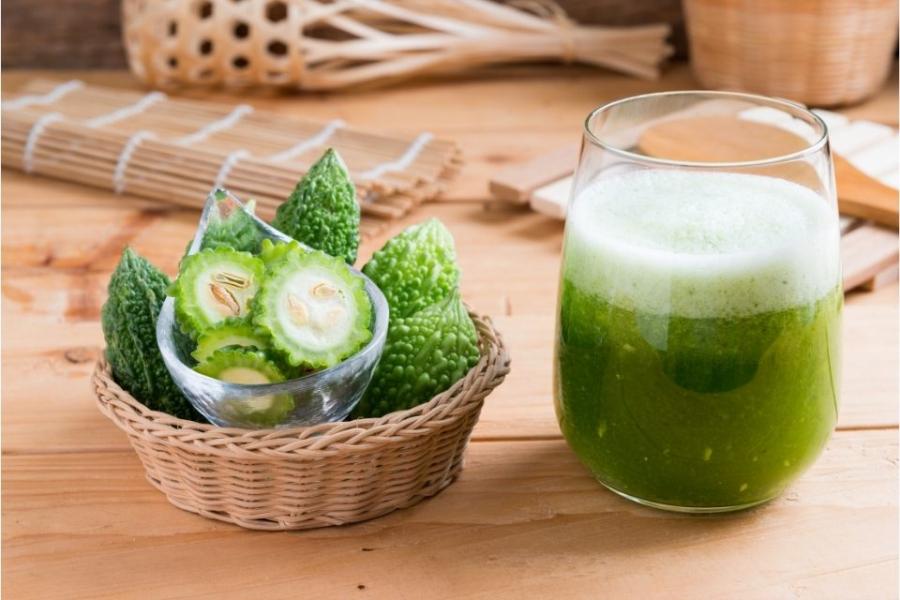 Rodajas de melón amargo en una cesta y zumo de melón amargo en un vaso.