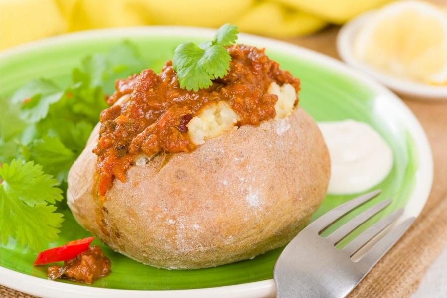 Una patata asada cubierta de chile con carne.