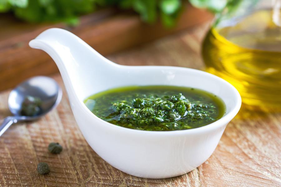 Un cucharón de loza con salsa verde italiana.