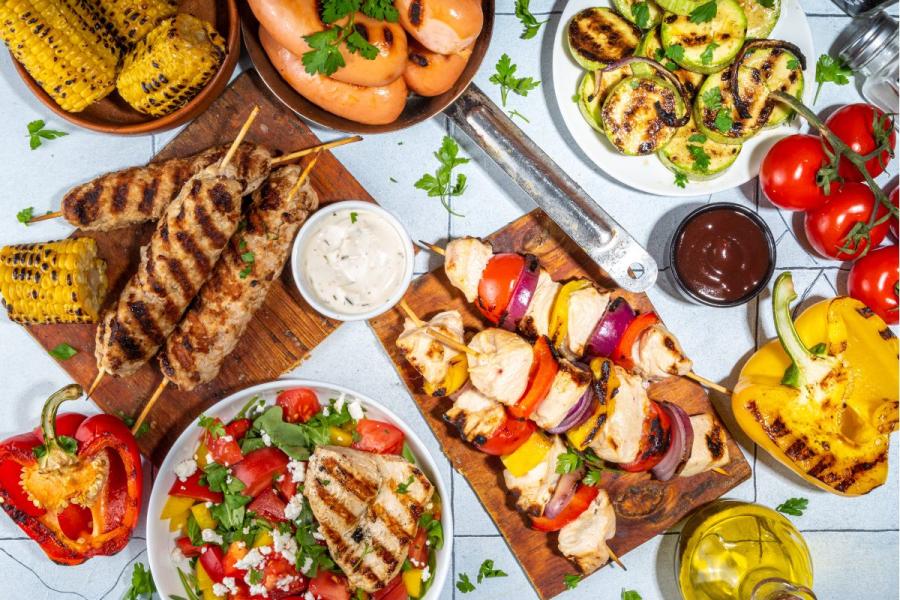 Barbacoa de verano con brochetas y verduras asadas.