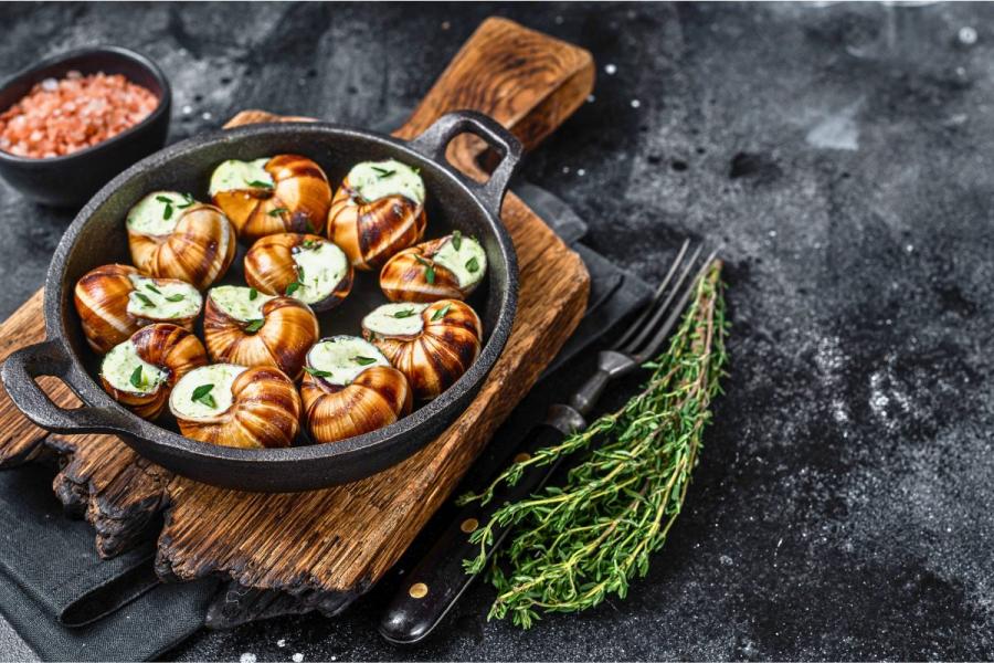 Una cazuela de fondo grueso con escargots bourguignonne.