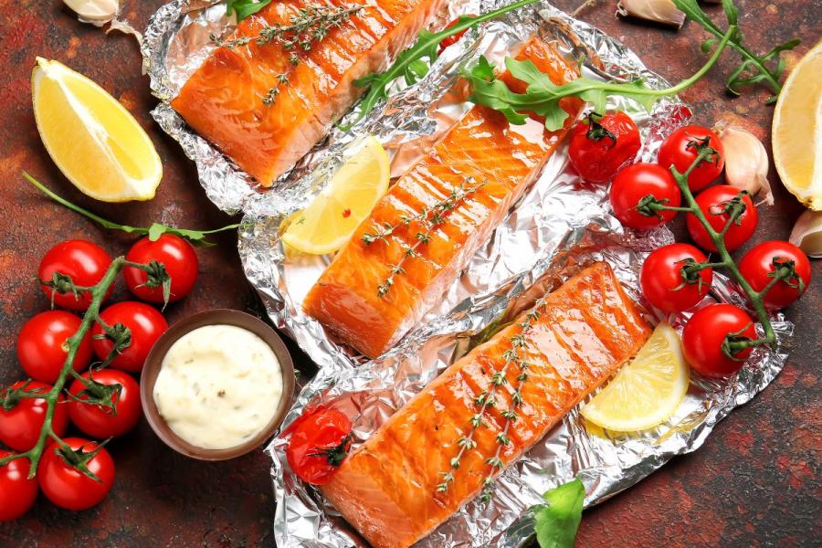 Filetes de salmón cocinados en papillote con limón, mantequilla y hierbas.