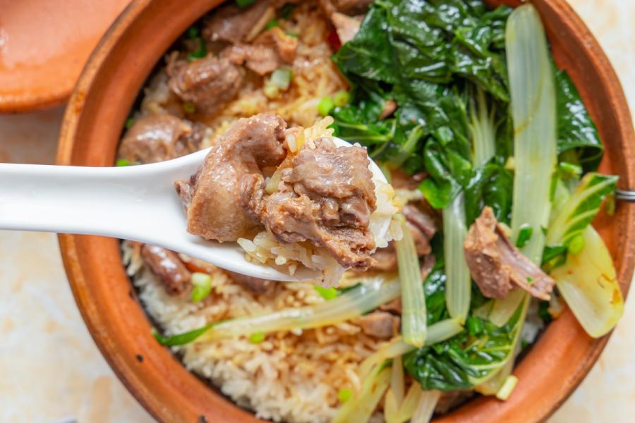 Un recipiente de cerámica con arroz y trozos de pichón escabechado.