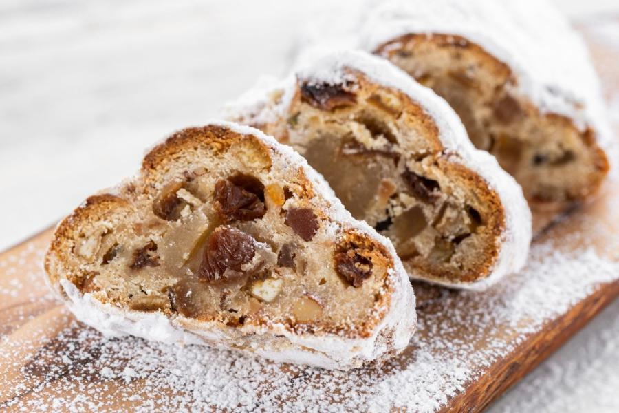 Stollen cortado en rebanadas encima de una tabla de cortar de madera.