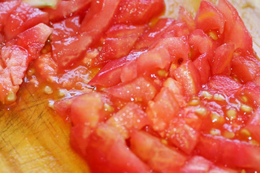 Tomate picado sobre una tabla de madera.