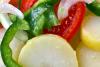 Detalle de una ensalada campera con patata, tomate, pimiento, cebolla y vinagreta.