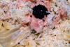 Detalle de pasta con salmón ahumado y falso caviar espolvoreada con parmesano rallado.