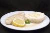 Pescado escalfado con arroz blanco y una rodaja de limón.