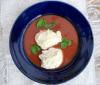 Sopa alemana de tomate decorada con queso crema y albahaca fresca.