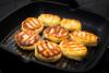 Syrniki, tortitas de queso fresco y blando fritas, en una sartén.