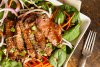 Ensalada oriental de carne con espinacas tiernas y semillas de sésamo.