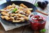 Kaiserschmarrn en sartén acompañado de compota de ciruelas.