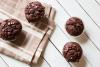 Bizcochitos de chocolate con pepitas de chocolate sobre una mesa de madera con un trapo de cocina.