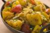 Patatas bombay en una sartén típica de la India.