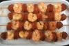 Brochetas de gambas y chorizo en una fuente de loza.