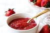Kétchup de fresa en un cuenco y fresas frescas.