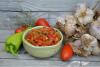 Un cuenco con piperade rodeado de algunos de los ingredientes.