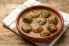 Una cazuela de barro con albóndigas en salsa.