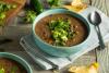 Sopa de frijoles negros adornada con aguacate y cilantro.