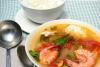 Gumbo con ocra, gambas y cangrejo servido con arroz blanco al lado.