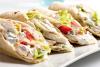 Burritos de pollo y verduras cortados por la mitad en diagonal.