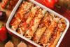 Una fuente de horno con enchiladas de pollo.