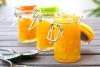 Tres recipientes de vidrio con mermelada de naranja.