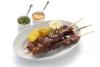 Anticuchos de corazón con patata cocida, choclo y salsas.