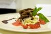 Codorniz con salsa al chocolate en un plato con su guarnición.