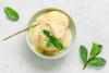 Helado de mango y leche de coco decorado con coco rallado y menta.