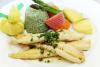 Un plato con filetes de lenguado en salsa acompañados con un molde de arroz verde, patatas y verduras cocidas.
