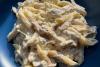 Un plato de pasta con pollo a la chilena con iluminación natural.
