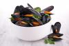 Un cuenco blanco con mejillones ya cocidos decorados con perejil.