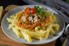 Un plato de pasta con salsa de lentejas.
