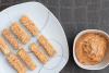 Tofu rebozado en sésamo y frito, acompañado de salsa de cacahuete.