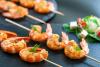 Brochetas de langostinos en pinchos de madera.