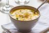 Sopa de calabaza decorada con hierbas y queso rallado.