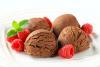 Helado de chocolate y almendras decorado con frambuesas frescas y hojas de menta.