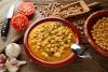 Una cazuela de barro con potaje de garbanzos y espinacas.