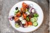 Ensalada griega con tomate, cebolla, pepino, queso feta y aceitunas.