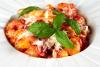 Ñoquis con tomate a la sorrentina decorados con albahaca fresca.