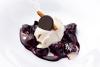 Cerezas al vino tinto acompañadas de helado, chocolate y canela en rama.