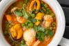 Un cacillo de loza con sopa de pescado y marisco.