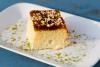 Un trozo de pastel de tres leches decorado con pistacho picado.
