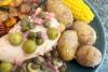 Un plato con pollo borracho al estilo argentino acompañado de patatas cocidas con piel, maíz tierno y ratatuille.